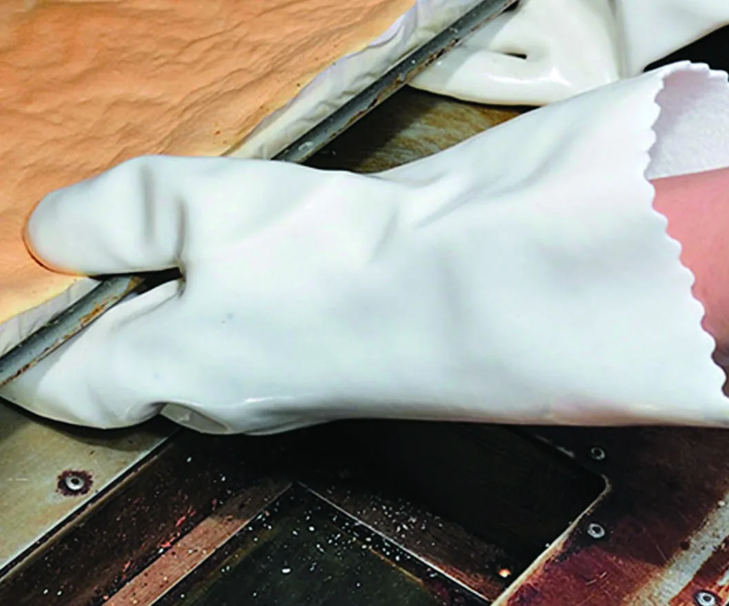 White 908 heat-resistant PVC glove shown against a heated industrial surface
