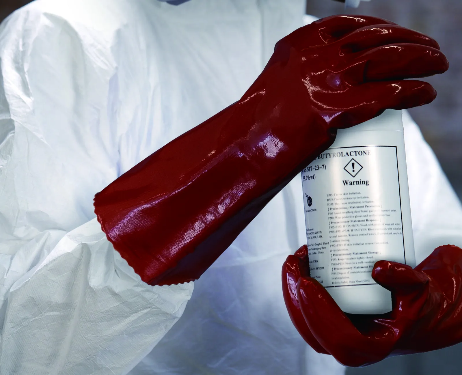 Red PVAX1 PVA gloves holding a solvent container in protective clothing