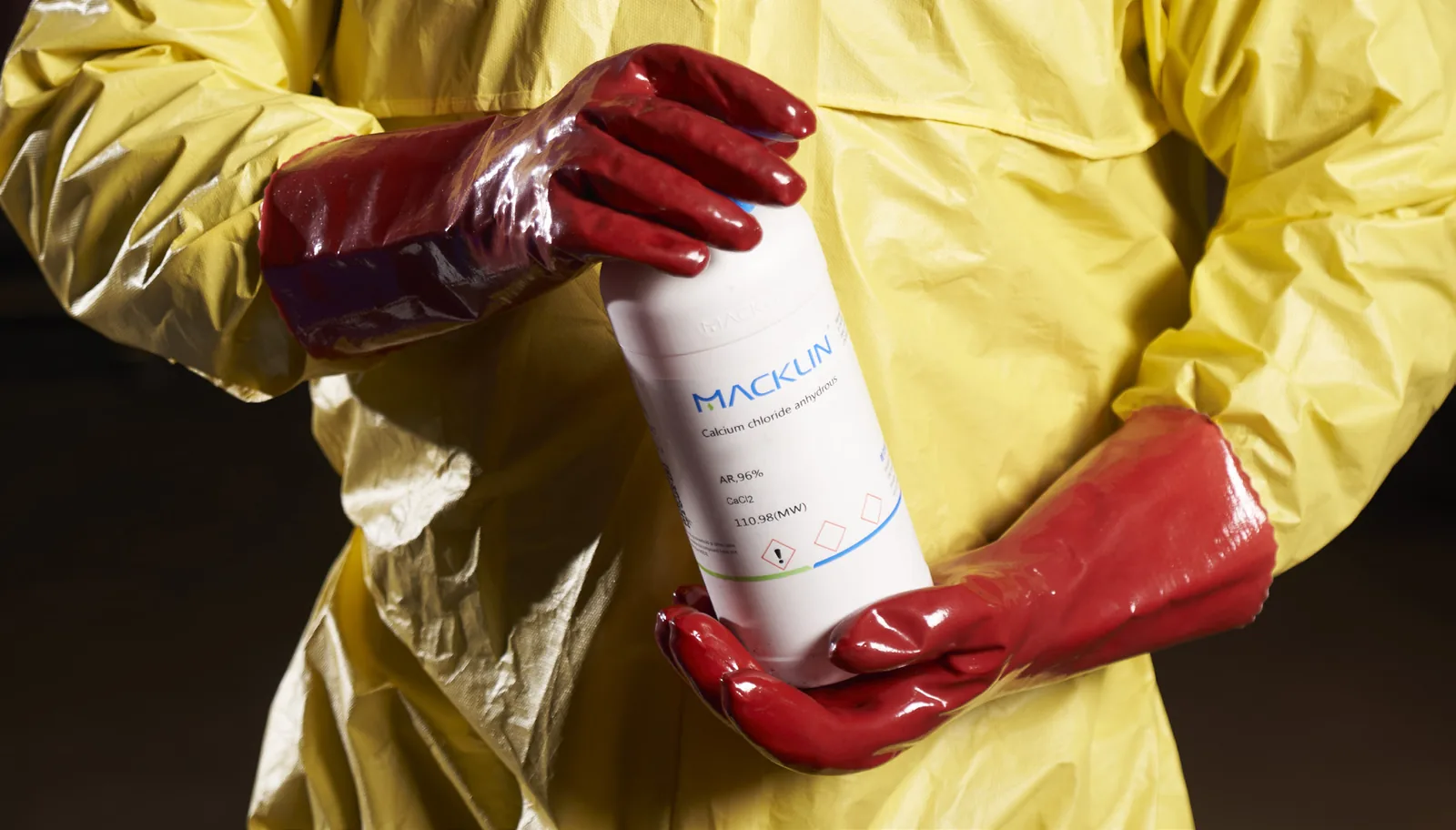 Red PVAX1 PVA gloves used to hold a chemical bottle