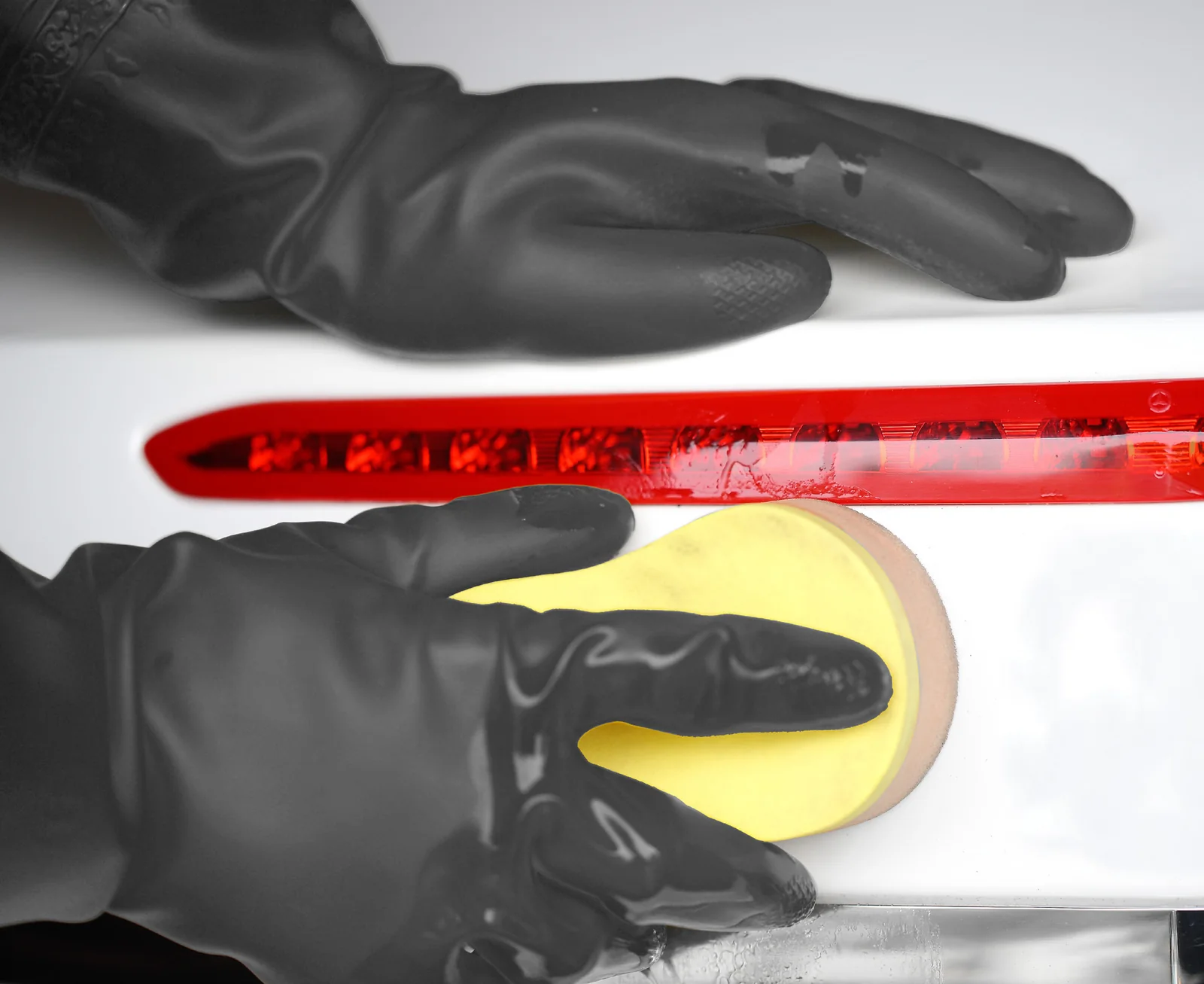 Black A32 PVC gloves cleaning a white surface with a sponge in the supplied OEM catalog