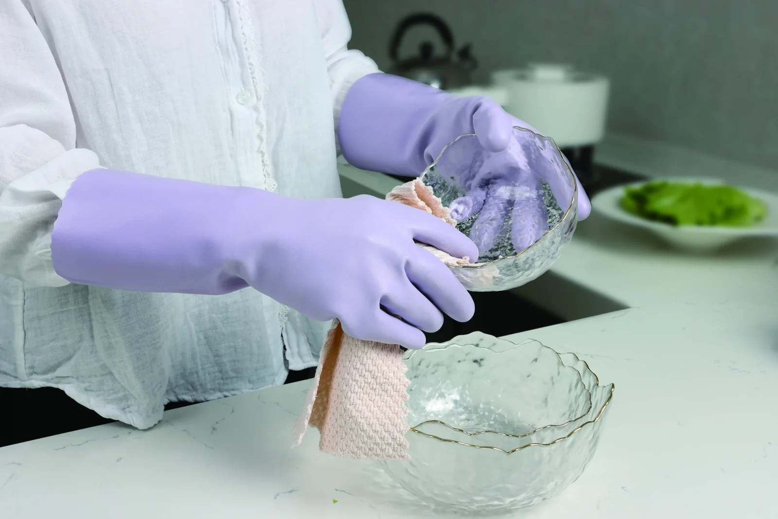 Purple DPU100 household gloves used to wipe a glass bowl in the catalog kitchen scene